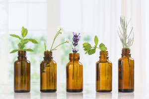 Essential oil bottles with flowers and herbs inside